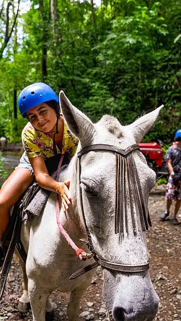 Woman bonding with her gentle Costa Rica stepping horse on the horseback waterfall tour in Jaco