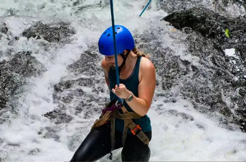 woman extreme rappelling down waterfall in jaco beach costa rica